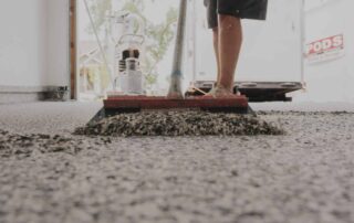 This image shows a man leveling epoxy flakes on the floor.