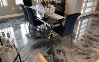 This image shows a dining area with black and gray metallic epoxy floor.